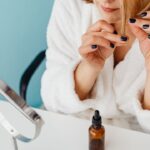 鏡の前で髪をケアする女性(自然な丸みの縮毛矯正のイメージ)